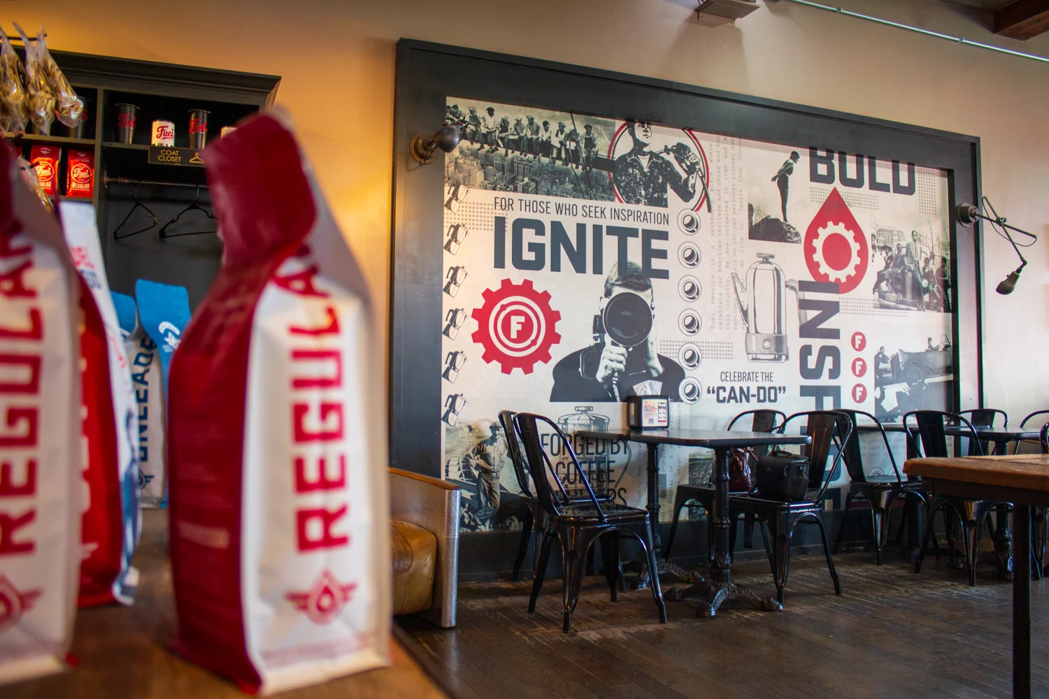 Fuel coffee bags beside mural artwork and café tables at Fuel America Brighton