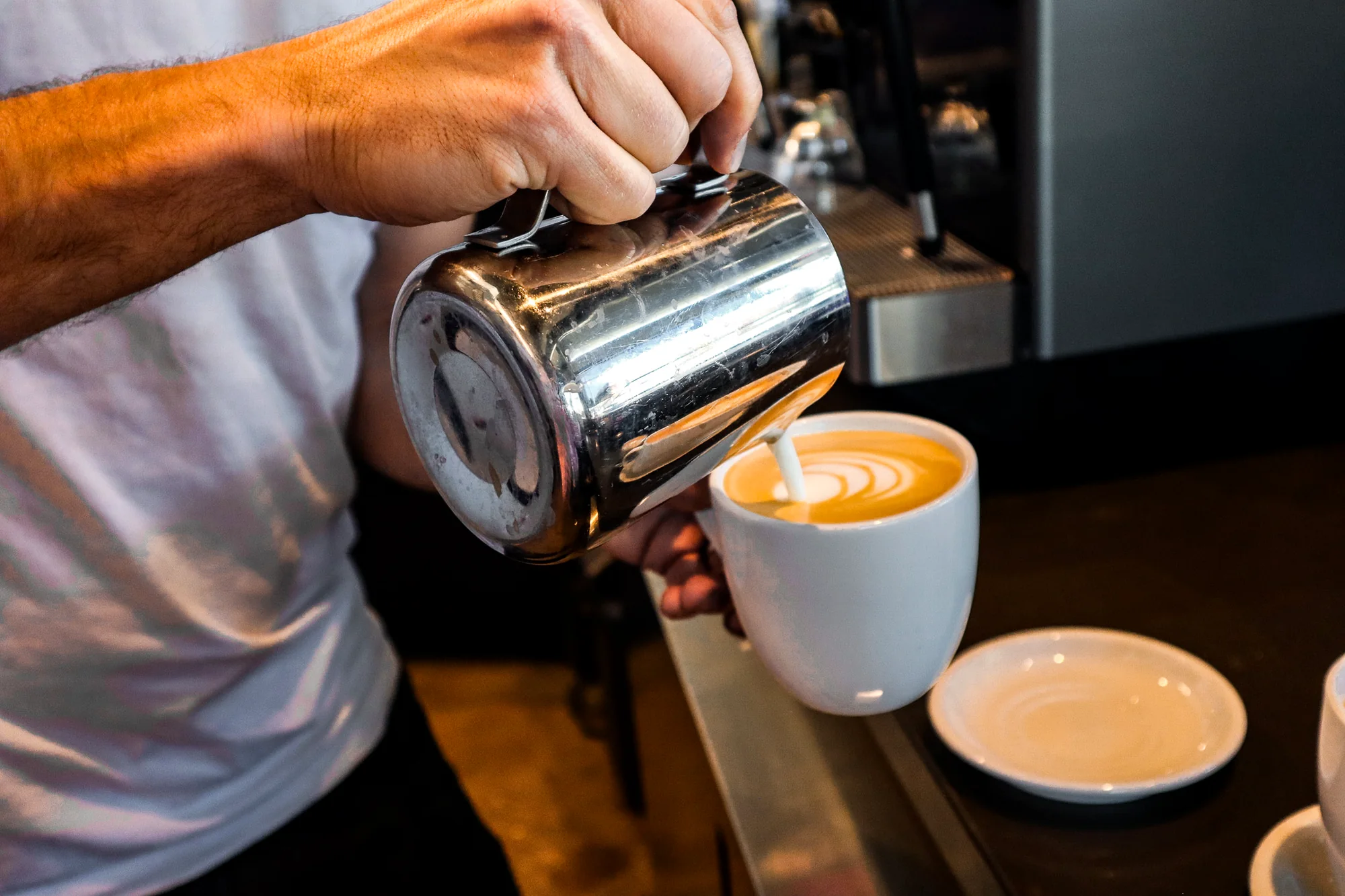 Milk being poured into espresso to make latte art at Fuel America.