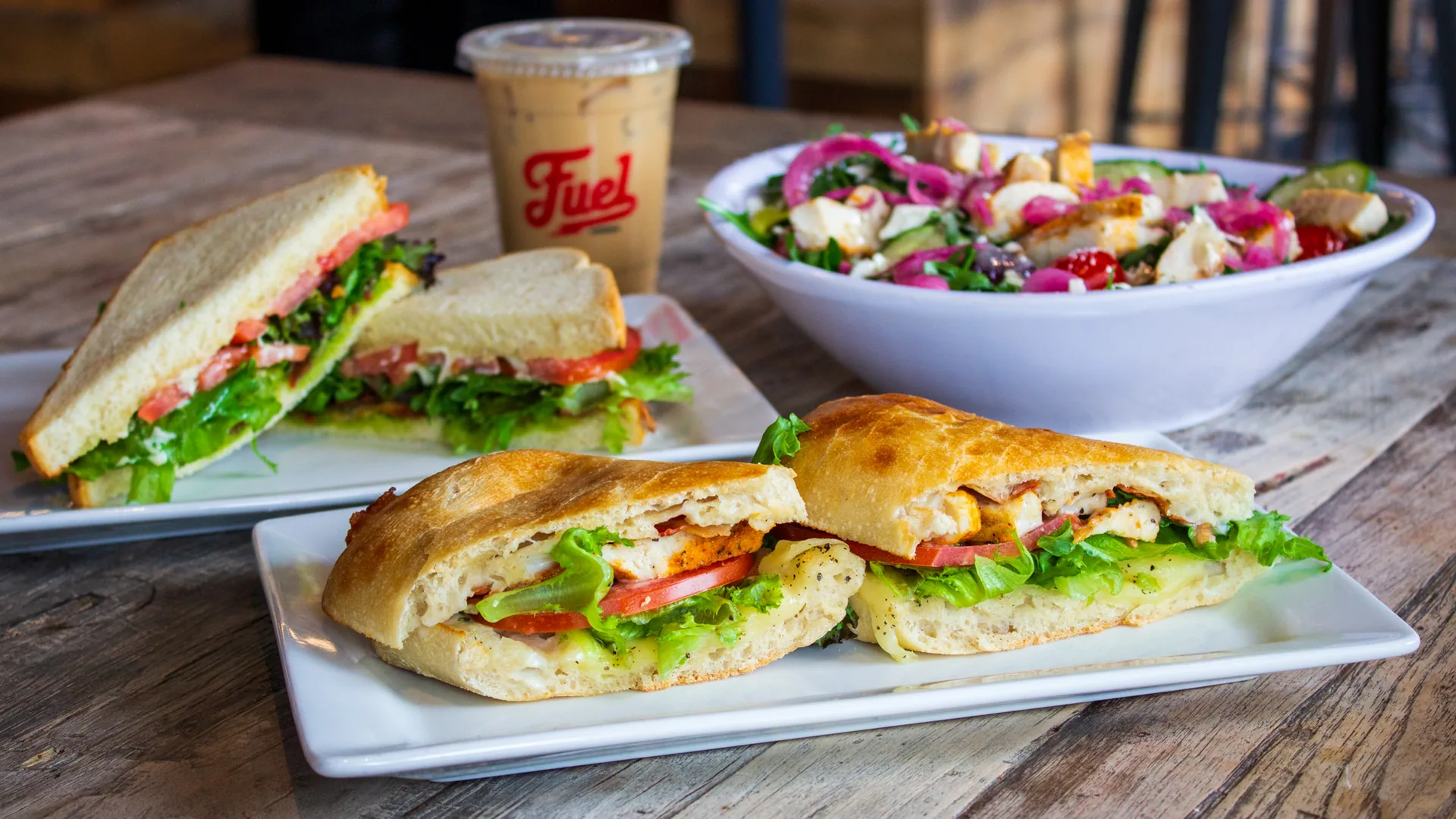 Fuel America lunch spread with branded iced coffee, sandwiches, and salad.